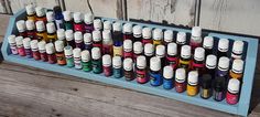 an assortment of different colored inks on a blue tray next to a wooden wall