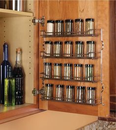 an open cabinet with spices and bottles in it