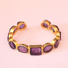 Wholesale Cuff Bracelet, Amethyst Cuff Bracelet, Gold Plated Cuff, Bezel Set Cuff Bracelet, Purple Stone Cuff, Birthday Gift Ideas Product Details Item Code: BJBB-2307 Stone Name: Amethyst Stone Shape : Pear, Round, Oval and Cushion Metal: 18K Yellow Gold Plated Over Brass Bracelets Inner dimension: 2.50" inch - Adjustable Note :- This bangles you will receive may vary slightly in color from the images because these are natural gemstones and vary to each other every single time and it is not possible to get the same color what is showing in the images. Images are for reference to get an idea of the similar color you will get. Shipping Info: All my items are safely and nicely packaged and shipped in a beautiful plastic box with bubbles wrap. The package is sent via international registered Adjustable Gemstone Cuff Bracelet For Anniversary, Handmade Amethyst Cuff Bangle Bracelet, Adjustable Purple Bangle With Gemstone, Adjustable Purple Gemstone Bangle, Handmade Amethyst Bangle As A Gift, Handmade Amethyst Bangle, Handmade Amethyst Bangle For Gift, Adjustable Purple Bracelet For Anniversary, Adjustable Purple Bracelets For Anniversary