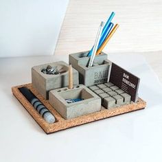 a pen holder made out of concrete blocks with pens, pencils and markers in it