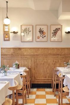 an empty restaurant with white tables and checkered flooring on the walls is pictured in this image