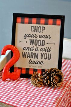 a sign that says chop your own wood and it will warm you up twice next to some pine cones