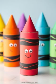 colorful crayons with faces drawn on them sitting in front of each other,