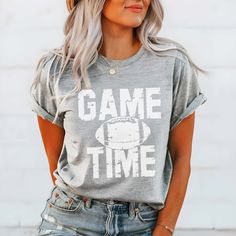 Get ready to cheer in style! Our Game Time Distressed Football Graphic Tee is perfect for showing off your love for the game. With its vintage-inspired design and comfy relaxed fit, this football tee is your go-to choice for game day festivities. Designed to look great with your favorite jeans and sneakers or a cute pair of booties, it’s versatile for any casual outing. The tee offers a flattering unisex fit, so everyone can join in the fun. If you prefer a more tailored look, consider sizing do Popular Graphic Tees, Football Trainer, Football Graphic Tee, Sports Mom Shirts, Fall Football, Cheer Shirts, Football Tee, Tshirt Ideas, Casual Work Outfit