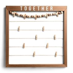 a wooden frame with clothes pins attached to it and the words together written on them