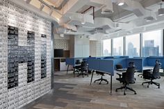 an empty office with desks and chairs in front of large windows overlooking the city