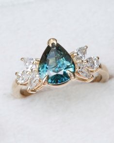 a blue and white diamond ring sitting on top of a table