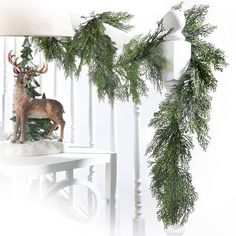 a white table topped with a deer figurine next to a christmas tree branch