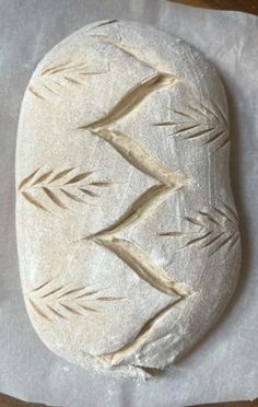 a piece of bread that is sitting on top of wax paper with leaves drawn on it