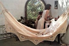 two women are sitting in a hammock with an old fashioned crochet pattern