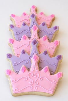 pink and purple decorated cookies in the shape of princess crowns