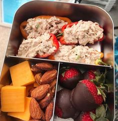 two trays filled with different types of food and fruit on top of each other