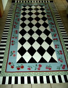 a black and white checkerboard floor with roses on the border is laid out