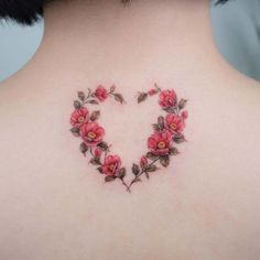 a woman's back with flowers in the shape of a heart