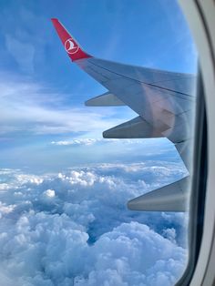 the wing of an airplane flying over clouds