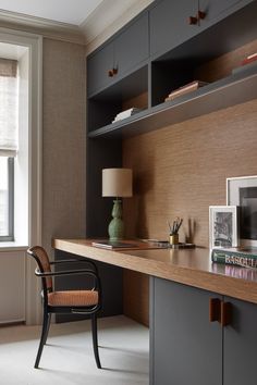 a chair sitting on top of a wooden desk in front of a book shelf next to a window