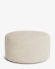 a white round ottoman sitting on top of a floor