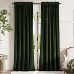 a living room with green curtains and a white chair