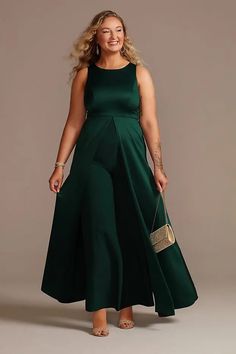 a woman in a long green dress is posing for the camera with her hand on her hip