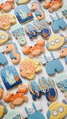 decorated cookies are displayed on a table for sale in a storefront window, including sea animals and seashells