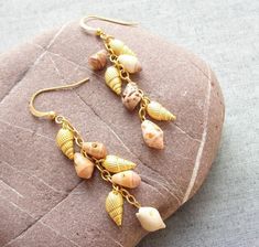 The sea has so much to give! After the sea urchin collection we wanted to show more of the possibilities coming from the sea. These earrings are made with 24kr gold plated shells, earwires and chain and real shell between them. An elegant and wonderful result! Very comfortable and light weighted. More sea treasures coming up, and we will gladly make the custom order to your wishes and dreams with sea treasures! The earrings are 2 3/4'' (7 cm) including the wires. All metal is gold plated (24kr), nickel and lead free. Will be sent by registered airmail. More sea treasures coming up, and we will gladly make the custom order to your wishes and dreams with sea treasures! Two shipping options: Registered airmail takes 15 - 30 days on average,it is cheap and safe but slow. TNT which takes 5-7 da Sea Treasure, Seashell Beach, Earrings Beach, Seashell Earrings, Beach Earrings, Golden Beach, Sea Urchin, Cluster Earrings