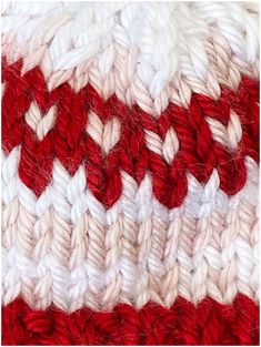 a close up view of a red and white crocheted blanket