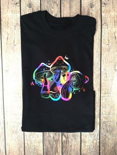 MAGIC MUSHROOM TEE - Funny Vegan tee, Unisex Cotton Shirt, Psychedelic Tee, Mushroom Lover Botanical Tee, Nature Lover Cottage Core T-Shirt Welcome to the Print Inc Store. We offer high quality, beautiful designs with a stylish twist. We create all our designs in house and we hope you like them just as much as we do. Good vibes only here! 🤙 - - - - - - - - - - - - - - - - - - - - - - - - - - - - - - - - - - FEATURES: -Psychedelic Mushroom Design -Premium 100% heavyweight cotton -Eco Friendly/Ve Trippy Shirt Designs, Black Crew Neck T-shirt With Rainbow Print, Black Short Sleeve T-shirt With Rainbow Print, Summer Graphic Tee With Mushroom Print, Black Graphic Tee With Mushroom Print, Black Crew Neck T-shirt With Mushroom Print, Black Crew Neck Top With Mushroom Print, Black Short Sleeve Top With Mushroom Print, Short Sleeve Tops With Mushroom Print For Streetwear