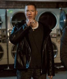 two men standing next to each other in front of washing machines