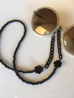 "If you are a woman who have a avant guard and unique sense of style, a fashion individual as opposed to fashion followers, you are in the right place to buy that eyegasses chain that will add a sophisticated touch to your reading glasses or even to your sunglasses. This eyeglasses holder is made with 4 mm black  beads, black chain  and lucite flowers. Hight quality eyeglass holder grips with extra strength elastic.Fit any frame size. I ship this in organza draw string bag. For you or as a gift it's ready to go. *Lenght: 65 cm (aprox. 25,6\").If tou want it in another lenght, just convo me." Black Adjustable Glasses Chain For Parties, Adjustable Chain Strap Glasses Chains, Adjustable Glasses Chains For Parties, Black Adjustable Glasses Chains, Adjustable Party Glasses Chains With Chain Strap, Elegant Black Glasses Chains For Party, Trendy Metal Glasses Chains For The Beach, Black Metal Glasses Chain With Adjustable Feature, Trendy Metal Glasses Chains For Beach