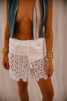 Upcycled Vintage French Crochet and Lace Patchwork Shorts – Handmade by Vagabond Ibiza These upcycled crochet shorts, crafted from vintage French crochet and lace panels, are an exquisite example of sustainable fashion. Carefully patchworked together in our Vagabond Ibiza studio, the lace and crochet elements create a striking new textile. The intricate detailing and delicate textures make these shorts a standout piece for summer or festival wear. Designed in a small size, the shorts fit the model, a UK size 8, comfortably. The combination of lace and crochet adds an elegant, feminine touch to the modern silhouette. • Material: Upcycled vintage French crochet and lace panels • Size: Small (Model is UK size 8) • Design: Patchwork design with intricate lace and crochet detailing • Details: H Crochet Lace Beach Shorts, Summer Beach Shorts With Crochet Details, Crochet Beach Shorts Asos, Beach Crochet Lace Shorts, Crochet Elements, French Crochet, Upcycled Crochet, Beige Lace Trim Shorts, Patchwork Shorts