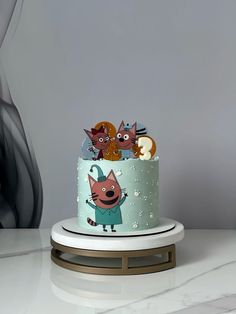 a three tiered cake with cartoon characters on it