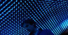 a man standing in front of a blue lit room with lots of lights on it