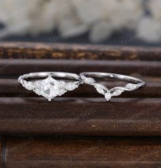 two wedding rings sitting on top of a wooden table