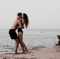 two people embracing each other on the beach