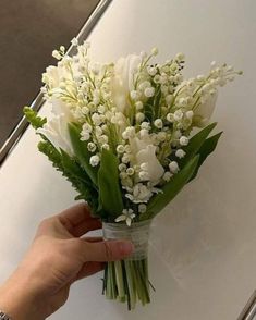 a person holding a bouquet of white flowers