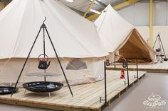 several tents are set up in the middle of a room with tables and chairs around them