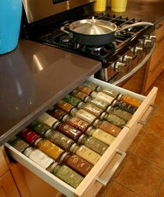 an open drawer in the middle of a kitchen with spices and condiments on it