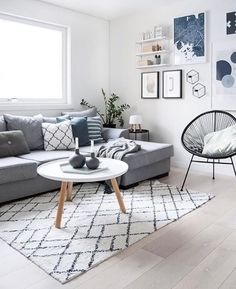 a living room filled with lots of furniture and pictures on the wall above it's windows