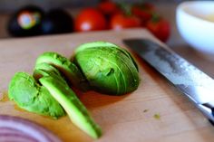 a knife and some green vegetables on a cutting board