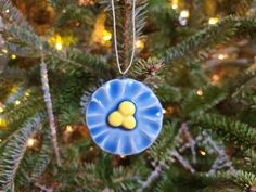 a blue ornament hanging from a christmas tree