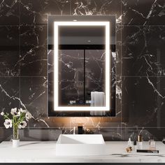 a bathroom sink with a lighted mirror above it and flowers on the counter in front of it