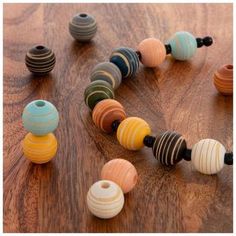 an assortment of wooden beads arranged on a table with one bead in the middle