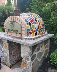 an outdoor pizza oven with colorful tiles on it