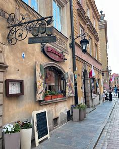 an old building with flowers and signs on the side