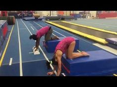 two women in pink shirts are doing exercises on blue blocks at an indoor race track