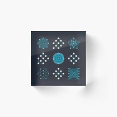 an array of blue and white geometric shapes acrylic print on black paper mounted on a wall