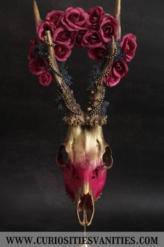 an animal skull with flowers on it's antlers