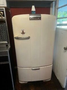 an old white refrigerator sitting in a kitchen