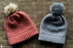 two knitted hats with pom - poms sitting on top of each other