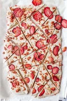 sliced strawberries and chocolate on a piece of parchment paper with toothpicks stuck in them